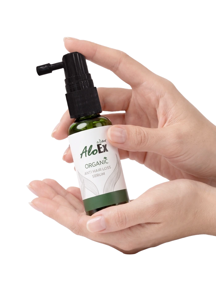 A hand holding AloEx Organic Anti Hair Loss Serum